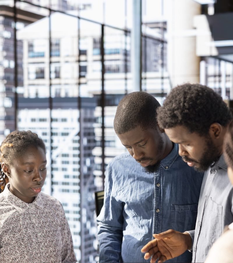 Black corporate team collaborates on global investment strategy, guided by a confident CEO with extensive expertise to work on data driven decisions. Solving administrative tasks in the office.